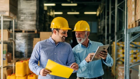 Men in hard hats walking in warehouse