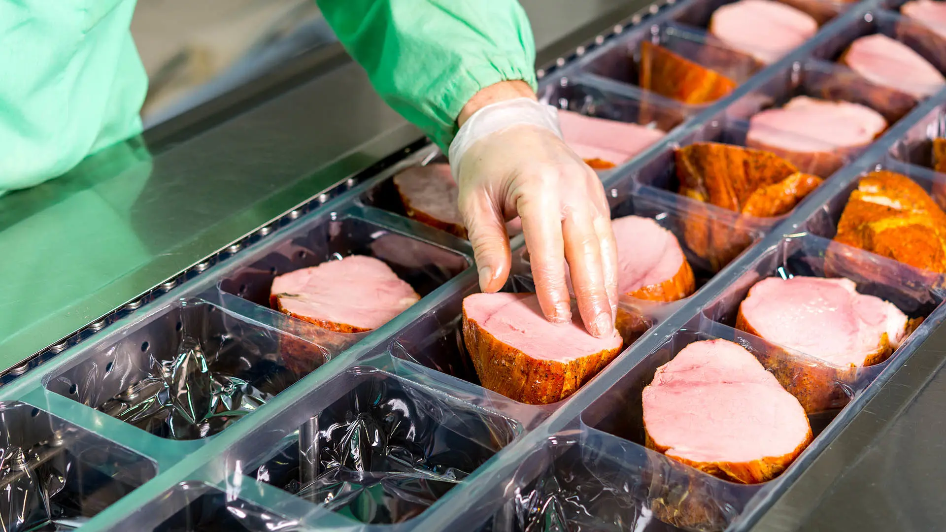 Person handling meat packaging.