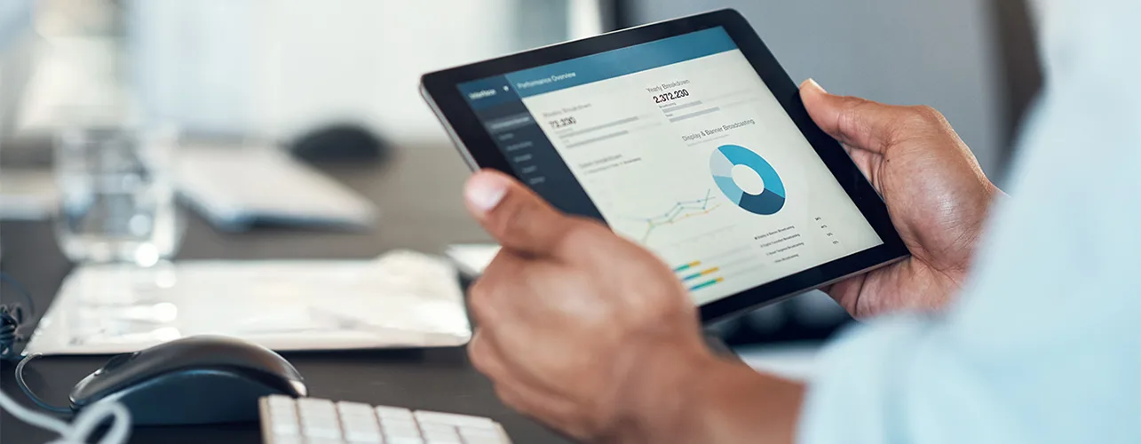 Hands holding a tablet displaying a chart