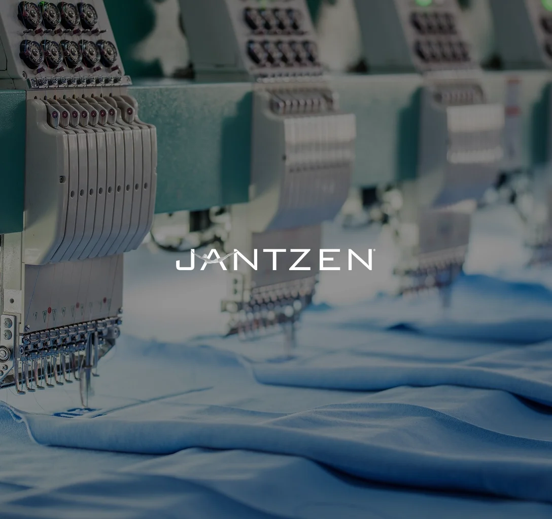 Jantzen Brands logo The Jantzen Brands logo against a backdrop of industrial sewing machines.