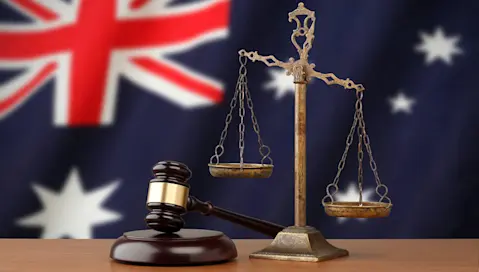 gavel and weight balance in front of Australian flag