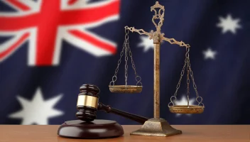 gavel and weight balance in front of Australian flag
