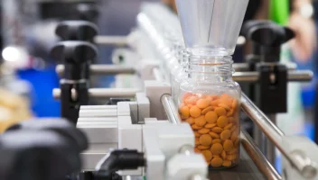 Bottle filled with pills on factory conveyor belt