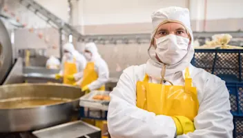 A food facility worker looks confident.