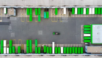Green trucks at a depot