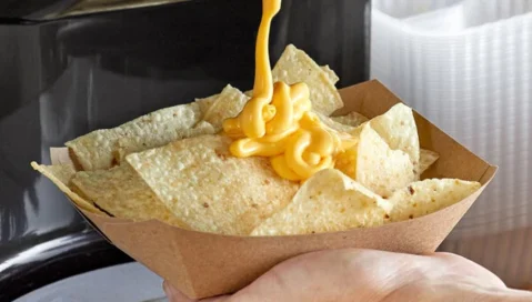 Nacho cheese sauce, drizzled over tortilla chips.