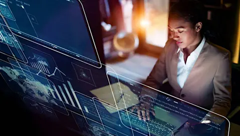 woman typing on keyboard with futuristic screens being projected