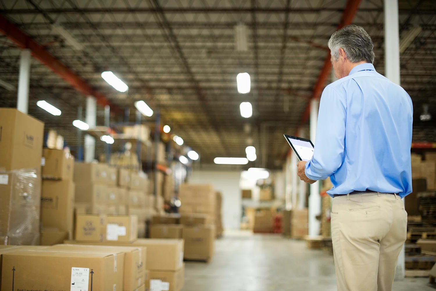 Businessman looking at warehouse with tablet