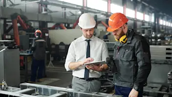 Manufacturing workers looking at tablet