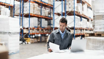 WMS implementation guy on laptop in warehouse