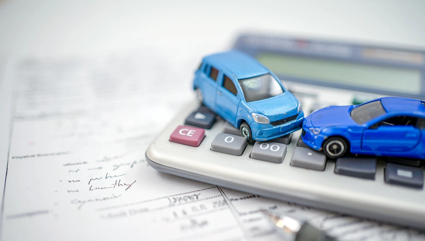 Toy cars on top of calculator resembling car accident.
