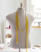 Mannequin with yellow tape measure on shoulders