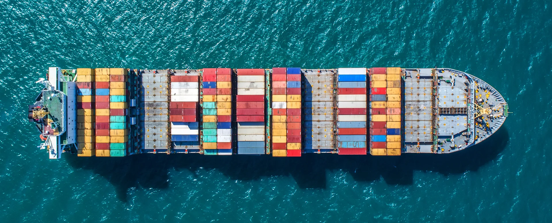 Aerial view of container ship transporting cargo containers at sea