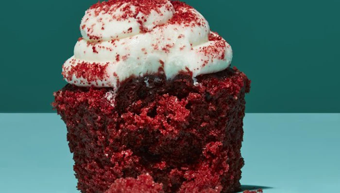 Cupcake with icing and sprinkles missing a bite