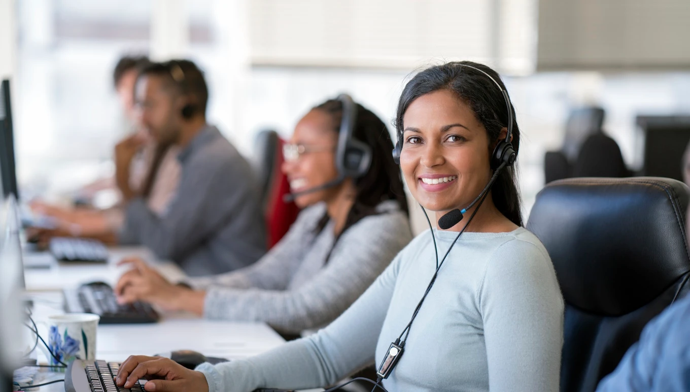 Smiling customer service rep at phone bank