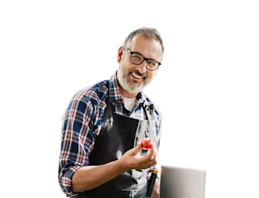 A man smiling holding a tomato.