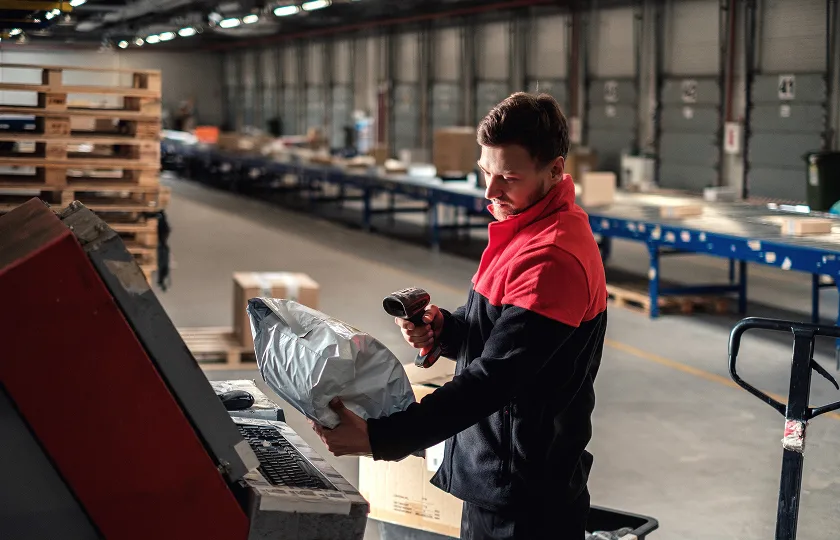 Warehouse worker scanning package with barcode scanner