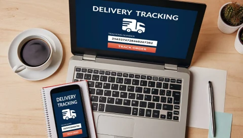 delivery tracking app on phone and laptop next to coffee cup