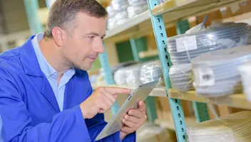 Man looking at inventory holding a clipboard.