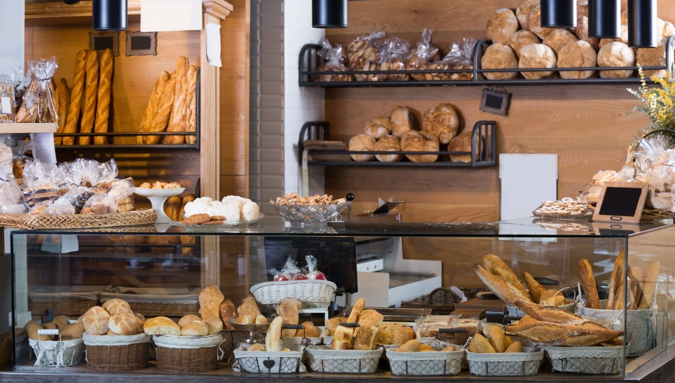 An assortment of fresh baked goods at a store counter,