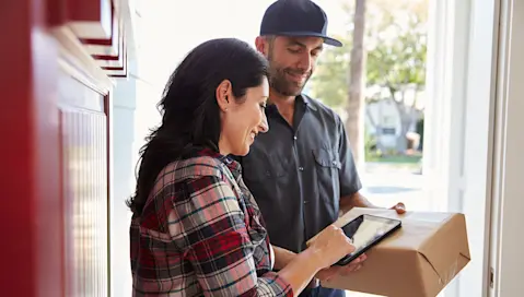 Woman signing for a package on a tablet