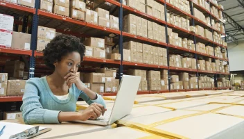 Women reviewing laptop in warehouse