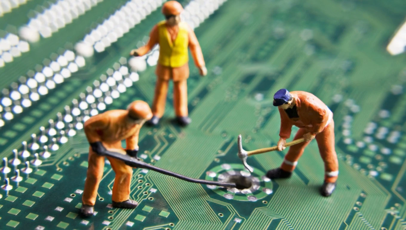 Construction toy figures mining a computer chip
