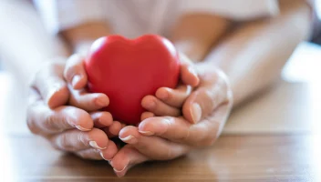 Adult and child hands holding a heart