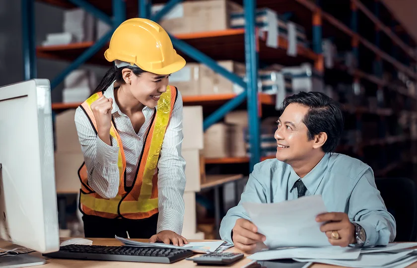 Warehouse worker and manager reviewing documents in distribution center