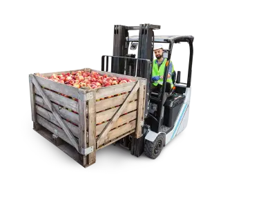 Pommes dans une caisse soulevée par un chariot élévateur à fourche