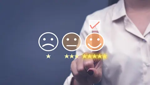 Three faces showing sad, neutral and happy expressions with a person pointing to the happy face
