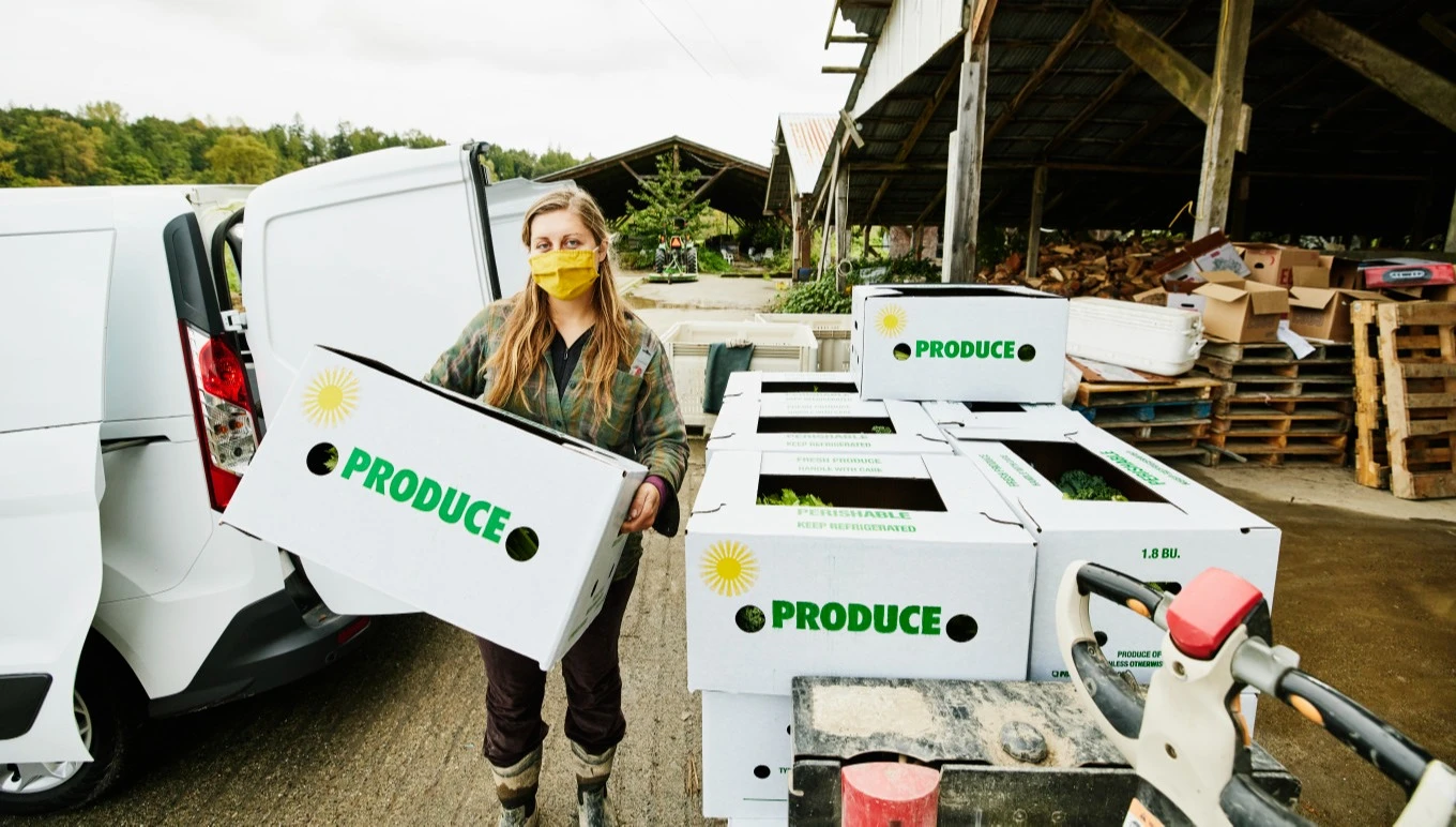 A food facility worker loads a van for transport of products.