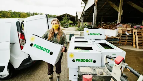 A food facility worker loads a van for transport of products.