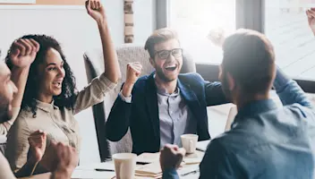 Group of people cheering in a meeting.