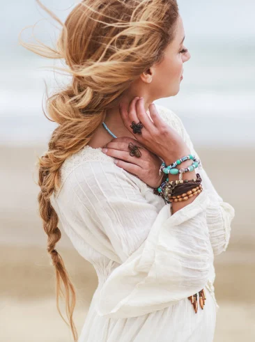 Woman standing on beach with wind blowing through hair