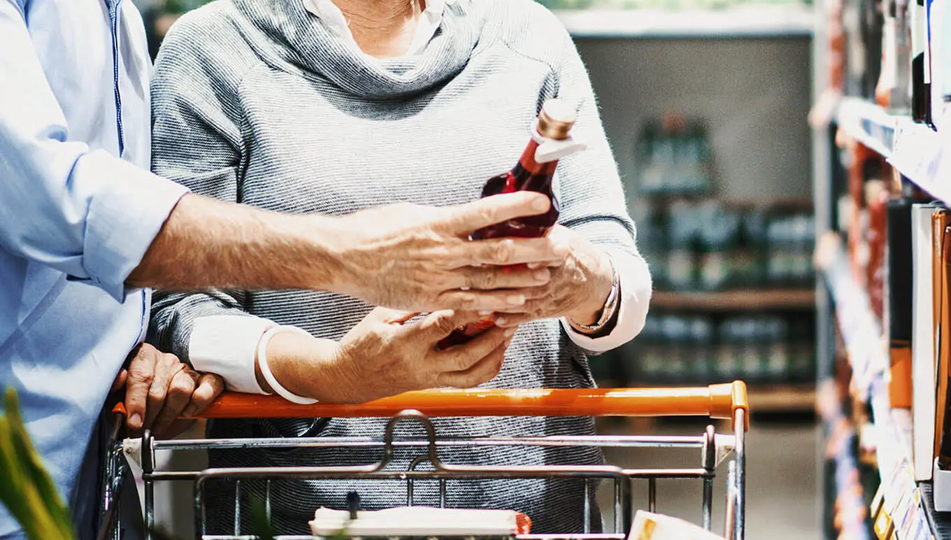 grocery shoppers holding bottle