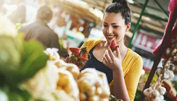 Woman picking strawberries from a market stall