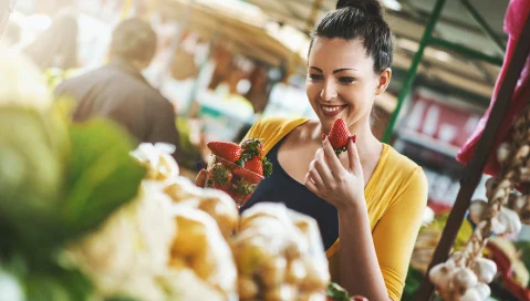 Woman picking strawberries from a market stall