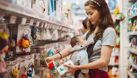 Woman with her baby shopping in toy section of store