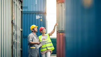 Dock workers reviewing cargo crates with tablet inventory