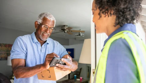 person accepting package from delivery worker