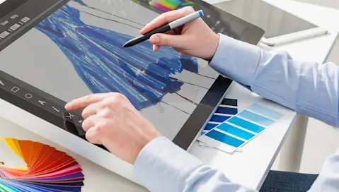 A person drawing a dress on a tablet.