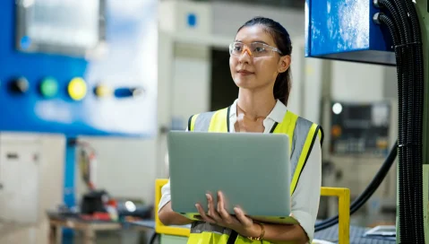 Worker wearing safety glasses using laptop