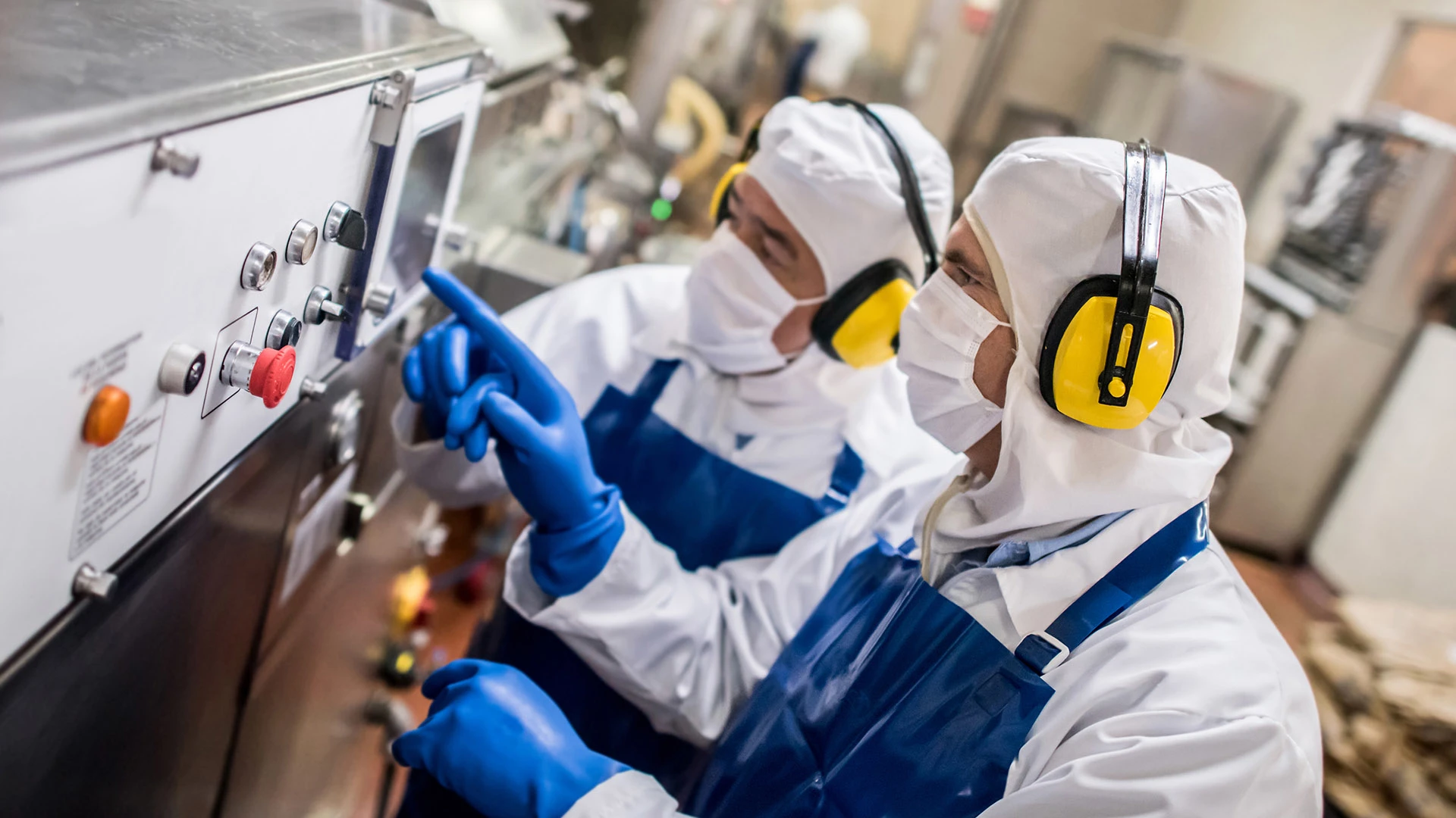 Deux hommes travaillant sur une machine dans une usine.