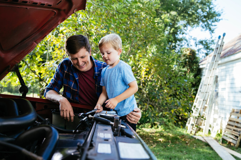Father working on fixing truck with his young son