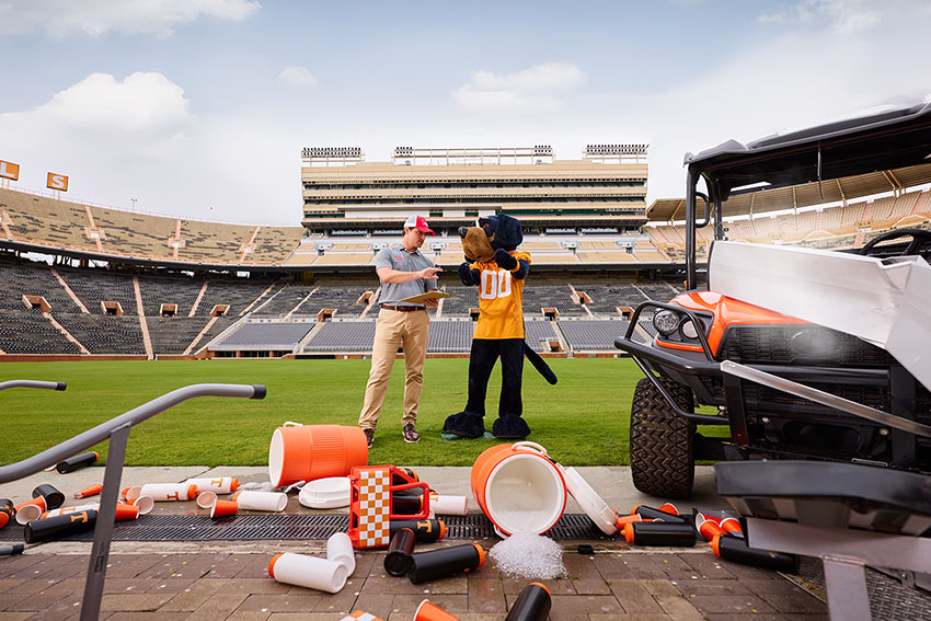 Farm Bureau Insurance of Tennessee agent meeting with Smokey, the Tennessee Vols mascot after he wrecked his vehicle in Neyland Stadium