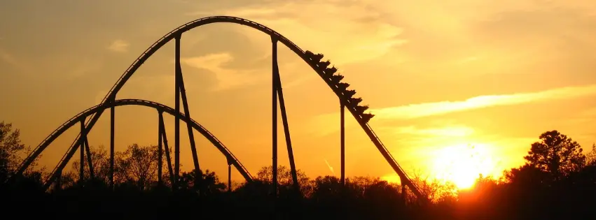 Rollercoaster with sunset and treeline in background