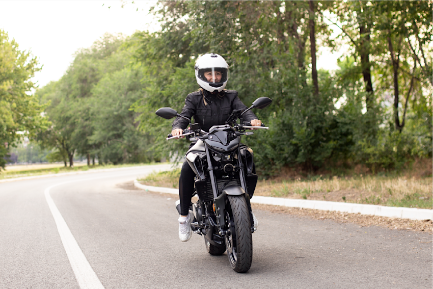 Motorcycle rider wearing helmet while riding motorcycle on open road