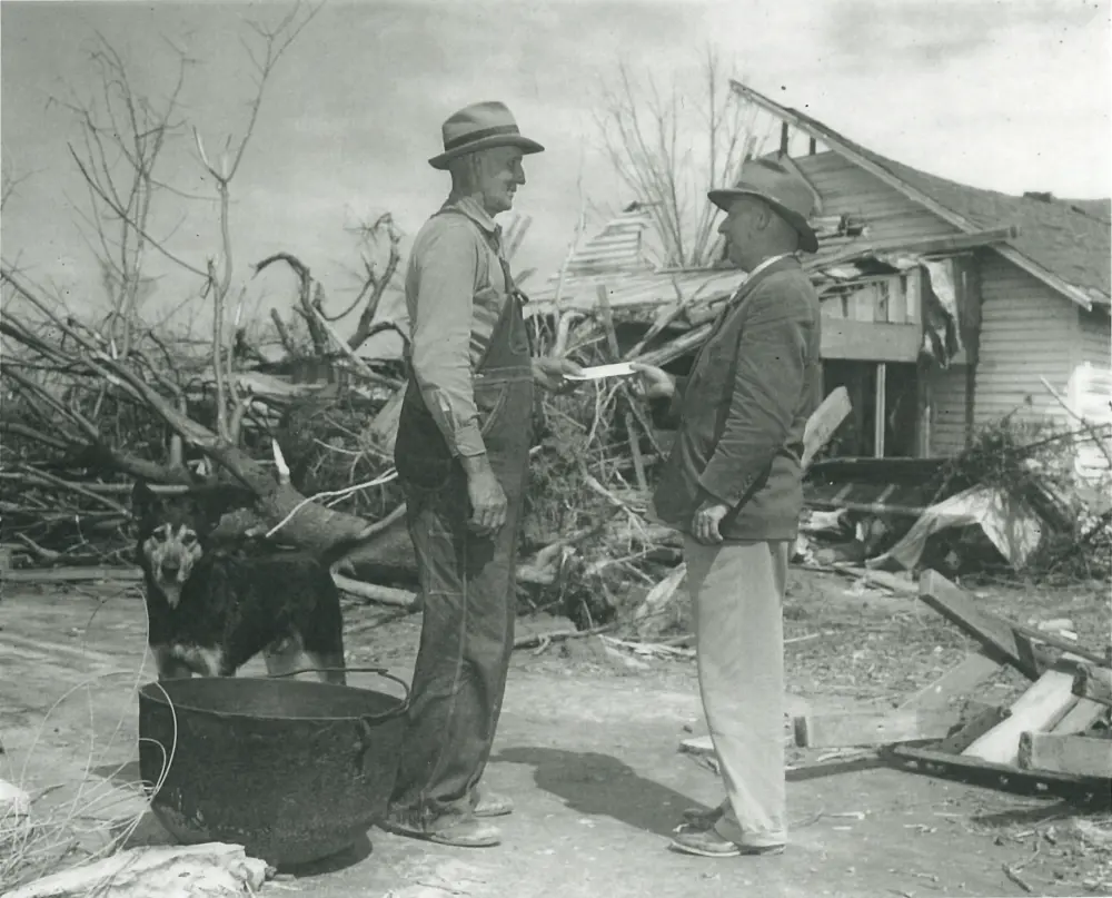 Farm Bureau Insurance Agent handing the first claim check to a local Tennessee farmer