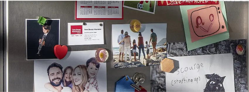 Refrigerator covered with pictures and magnets in a family home kitchen